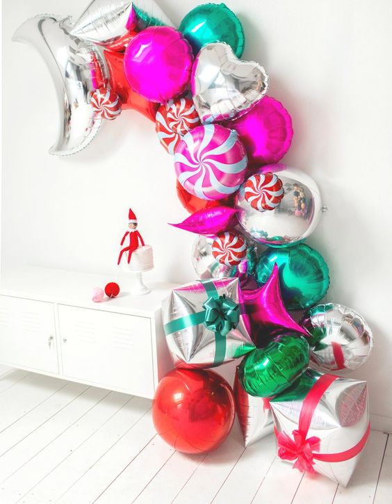 balloon arch made of pink, green, and red balloons with candy shaped balloons