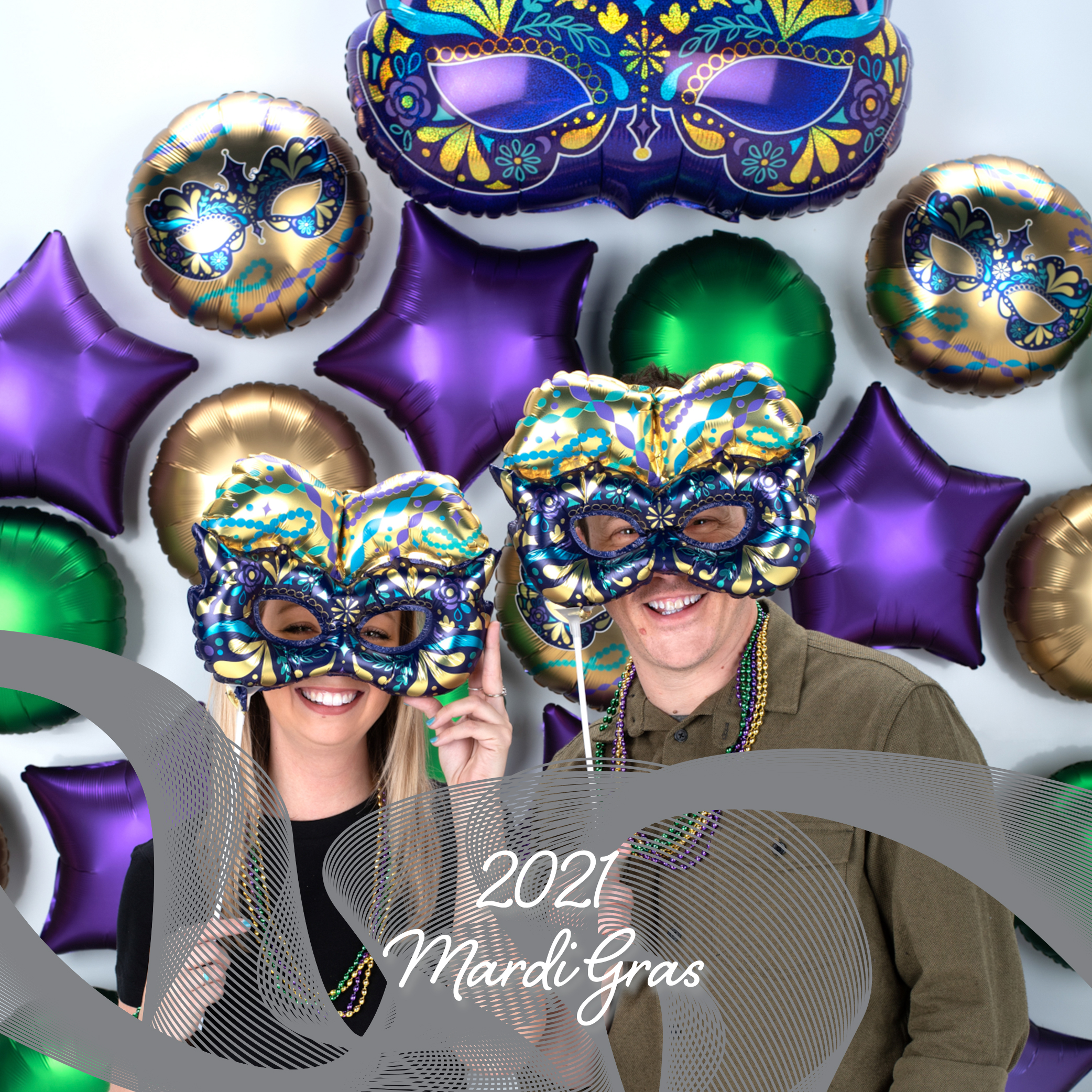 a man and a woman wearing mardi gras masks in front of balloons